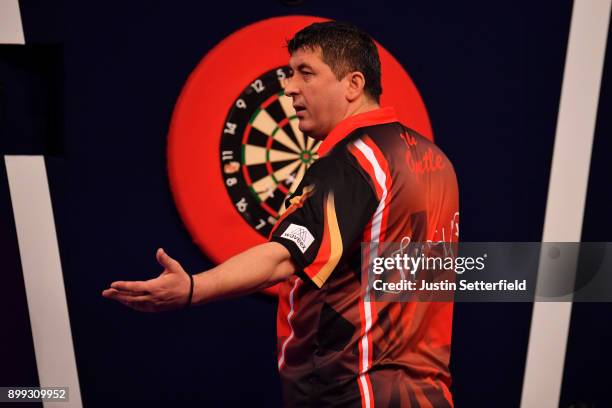 Mensur Suljovic reacts during his Third Round Match against Dimitri Van Den Bergh during the 2018 William Hill PDC World Darts Championships on Day...