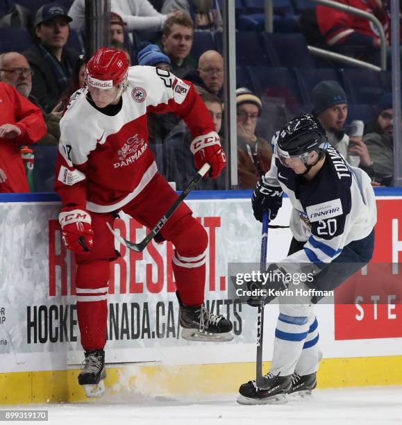 Eeli Tolvanen of Finland checks Joachim Blichfeld of Denmark in the first period during the IIHF World Junior Championship at KeyBank Center on...