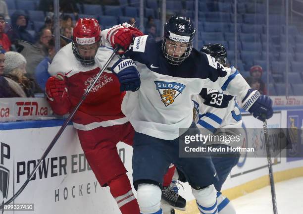 Rasmus Kupari of Finland checks Lasse Mortensen of Denmark in the second period during the IIHF World Junior Championship at KeyBank Center on...