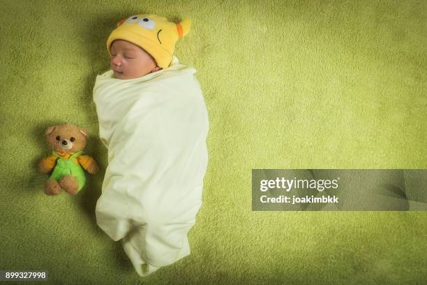 newborn baby boy wrapped in swaddle with teddy bear - baby blanket stock pictures, royalty-free photos & images