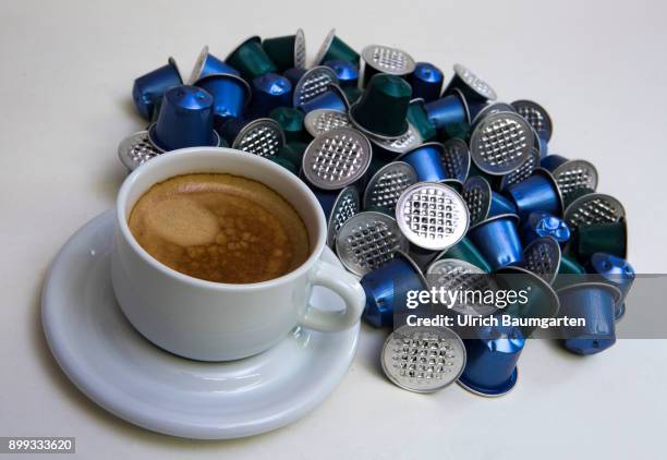 Symbol photo on the topic coffee, enviroment, waste, etc. The picture shows coffee capsules and a cup of coffee.