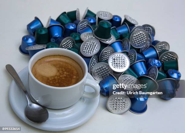 Symbol photo on the topic coffee, enviroment, waste, etc. The picture shows coffee capsules and a cup of coffee.