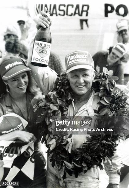 Cale Yarborough of Hardee's celebrates in victory lane with Miss Winston after winning the Van Scoy Diamond Mile 500 on June 10, 1984 in Long Pond,...