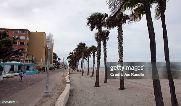 Pedestrian walks on the nearly empty broadwalk next to the beach on August 19, 2009 in Hollywood, Florida. An estimated 20.1 million people visited...