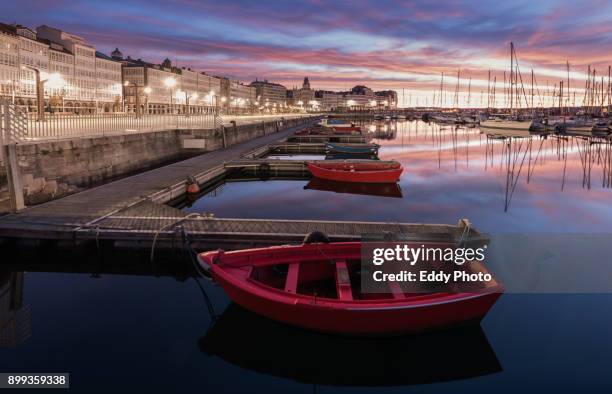sunrise at " la darsena" of la coruña with wooden boats at the foreground - darsena stock-fotos und bilder