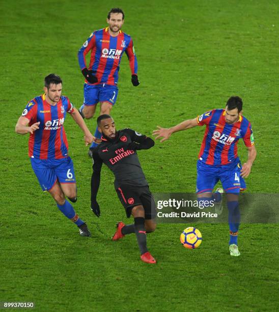 Alexandre Lacazette of Arsenal is closed down by Scott Dann, Luka Milivojevic and Johan Cabaye of Palace during the Premier League match between...