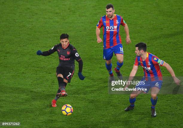 Alexis Sanchez of Arsenal passes the ball under pressure from Scott Dan and James McArthur of Palace during the Premier League match between Crystal...