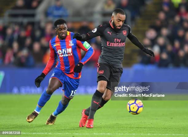 Alex Lacazette of Arsenal holds off Jeffrey Schlupp of Palace during the Premier League match between Crystal Palace and Arsenal at Selhurst Park on...