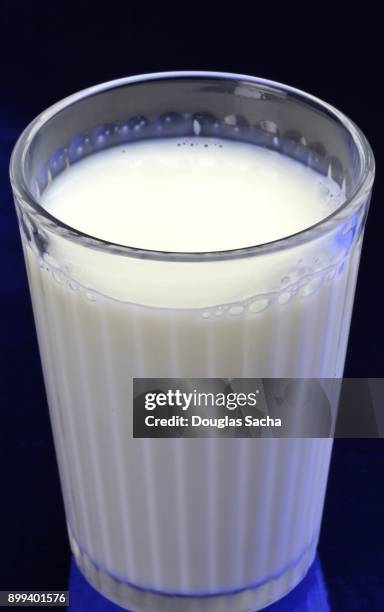 clear serving glass of fat free milk (bos primigenius) - bos taurus primigenius stock pictures, royalty-free photos & images