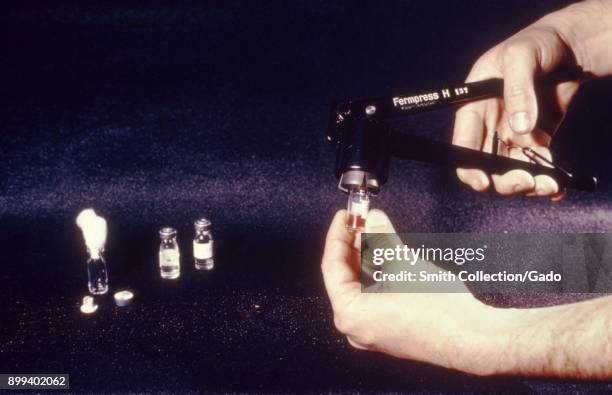 Technician, using a crimper, carefully seals vials with vertebrate samples, for an arbovirus presence test, 1974. Image courtesy Centers for Disease...