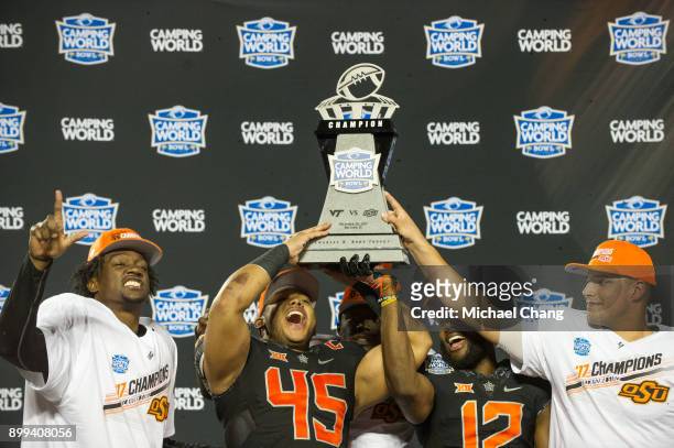 Safety Tre Flowers, linebacker Chad Whitener, linebacker Kirk Tucker and quarterback Mason Rudolph of the Oklahoma State Cowboys celebrate after...