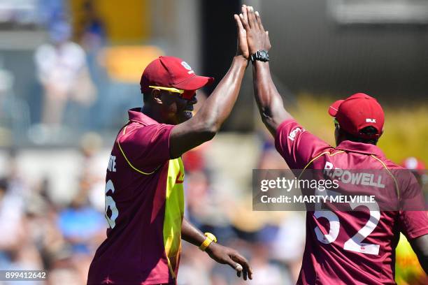 West Indies bowler Carlos Brathwaite celebrates with teammate Rovman Powell after catching New Zealand's Colin Munro during the first Twenty20...