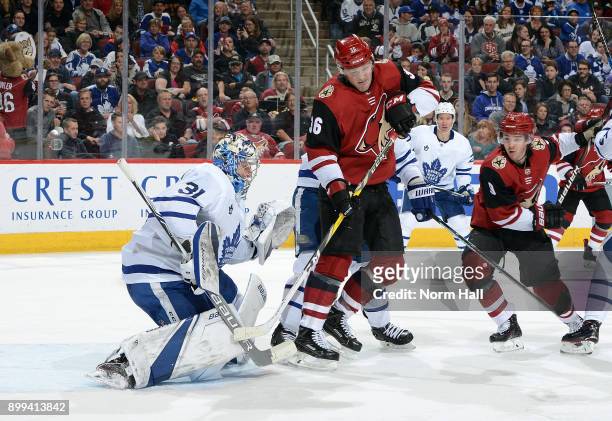 Goalie Frederik Andersen of the Toronto Maple Leafs makes a glove save in front of Christian Fischer of the Arizona Coyotes during the second period...