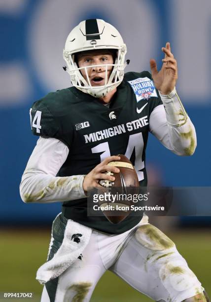 Michigan State Spartans quarterback Brian Lewerke scrambles with the ball in the second quarter of the Holiday Bowl played against the Washington...