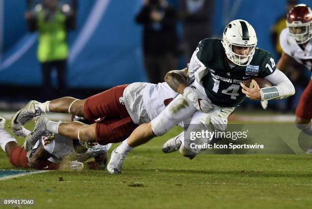 Michigan State Spartans quarterback Brian Lewerke is tackled from behind after gaining yards on a scramble by Washington State Cougars linebacker...