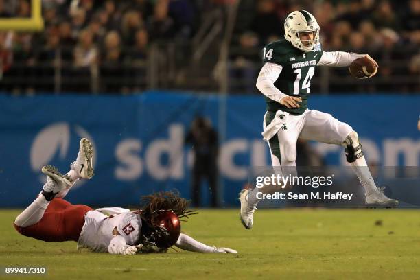 Brian Lewerke of the Michigan State Spartans eludes Jahad Woods of the Washington State Cougars during the first half of the SDCCU Holiday Bowl at...