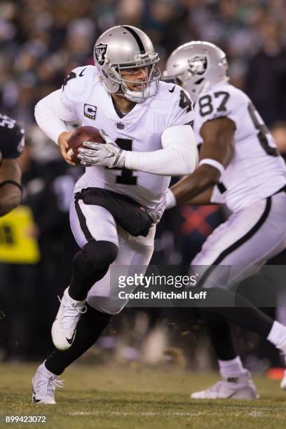 Derek Carr of the Oakland Raiders hands the ball off against the Philadelphia Eagles at Lincoln Financial Field on December 25, 2017 in Philadelphia,...