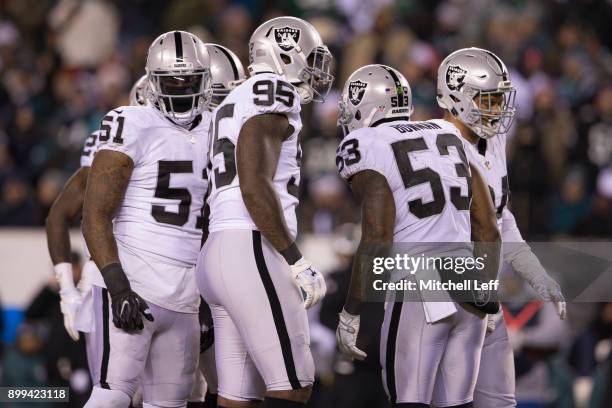 Bruce Irvin, Jihad Ward, and NaVorro Bowman of the Oakland Raiders huddle against the Philadelphia Eagles at Lincoln Financial Field on December 25,...