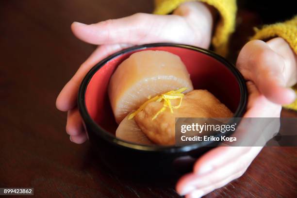 woman showing bowl of radish dish - aburaage stockfoto's en -beelden