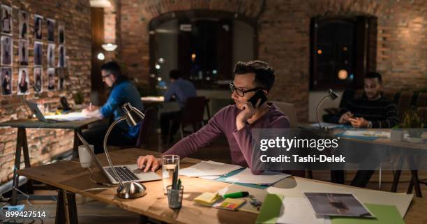 young businessman working late - graphic design studio stock pictures, royalty-free photos & images