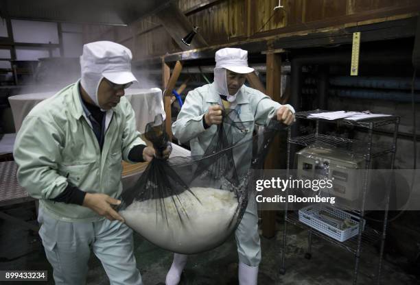 Employees transport steamed rice at a Suehiro Sake Co. Brewery in Aizuwakamatsu, Fukushima, Japan, on Thursday, Nov. 30, 2017. For the past five...