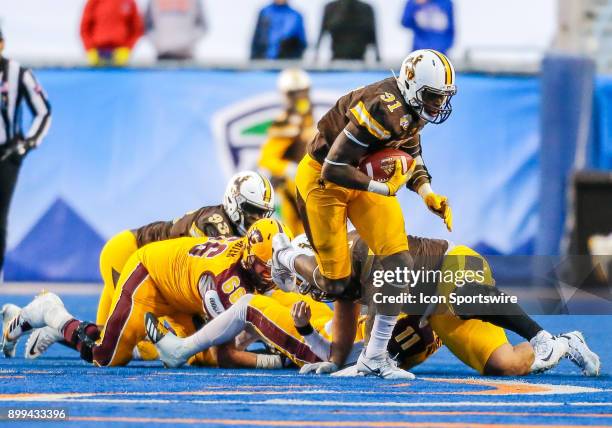 Wyoming Cowboys defensive end Carl Granderson turns up field with the ball after a fumbled by Central Michigan Chippewas quarterback Shane Morris...