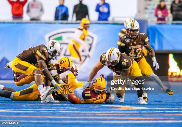 Wyoming Cowboys defensive end Carl Granderson reaches out for the ball the was fumbled by Central Michigan Chippewas quarterback Shane Morris during...