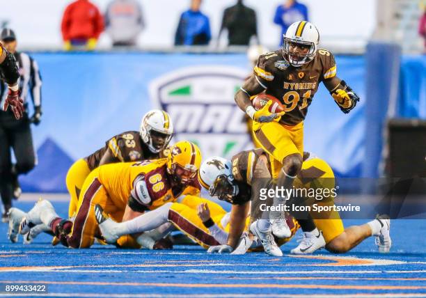 Wyoming Cowboys defensive end Carl Granderson turns up field with the ball after a fumbled by Central Michigan Chippewas quarterback Shane Morris...