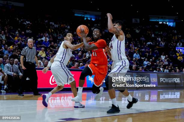 Sam Houston State Bearkats guard John Dewey III drives to the basket against LSU Tigers forward Wayde Sims and guard Tremont Waters on December 19,...