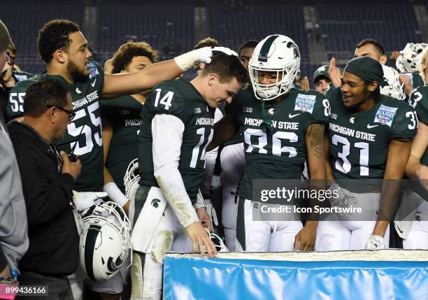 Michigan State Brian Lewerke is congratulated by his team mates after being named the offensive player of the game during the Holiday Bowl game...