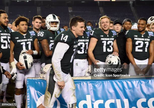 Michigan State Brian Lewerke is congratulated by his team mates after being named the offensive player of the game during the Holiday Bowl game...