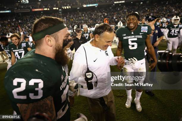 Chris Frey and Andrew Dowell congratulate head coach Mark Dantonio of the Michigan State Spartans after defeating Washington State Cougars 42-17 in...