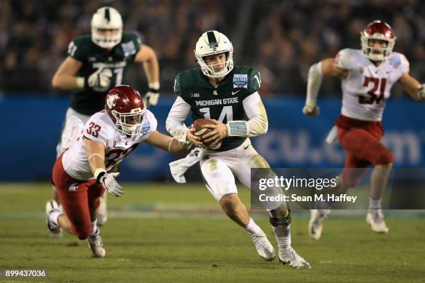 Brian Lewerke of the Michigan State Spartans eludes Dylan Hanser of the Washington State Cougars on a run play during the second half of the SDCCU...