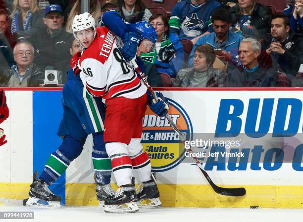 Teuvo Teravainen of the Carolina Hurricanes checks Brendan Gaunce of the Vancouver Canucks during their NHL game at Rogers Arena December 5, 2017 in...