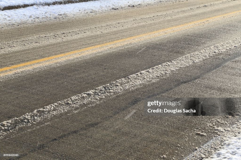 Close-up of a asphalt paved roadway covered with slushy snow