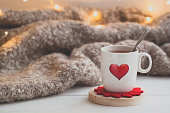 Festive Cup of tea with a smoke and a red heart over the knitted plaid