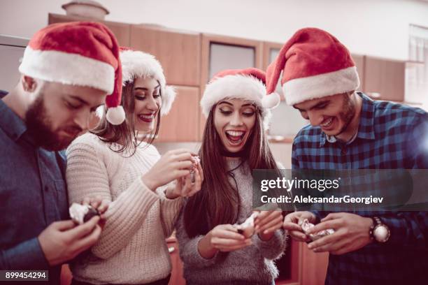 group of people unwrapping and eating sweets and drink coffee at christmas party - sugary coffee drink stock pictures, royalty-free photos & images