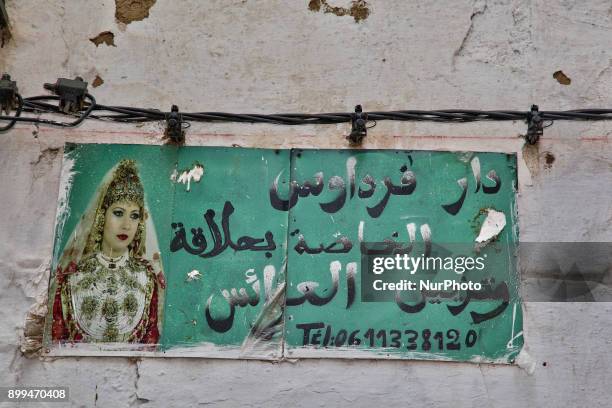 Sign with the image of a Moroccan bride above a shop in a souk in Tetouan, Morocco, Africa.