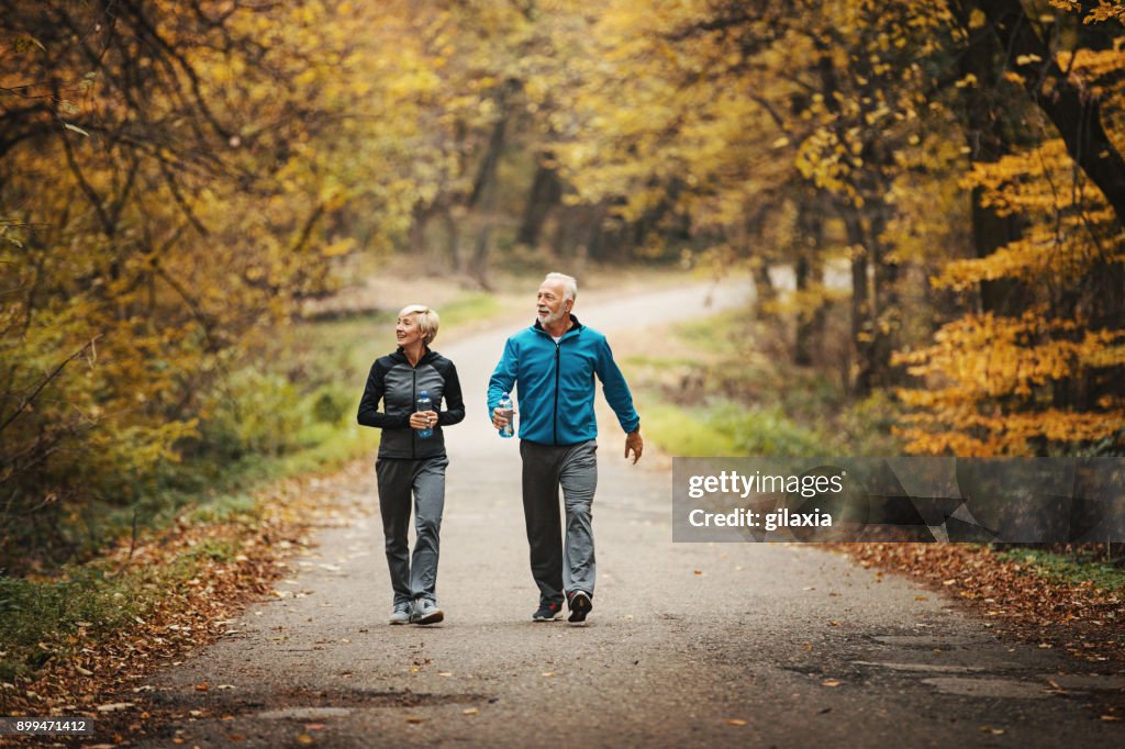 Senior couple power walking in a park.