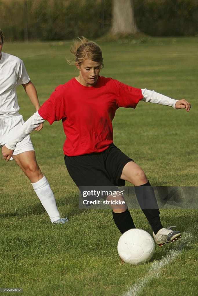Joven mujer jugador de fútbol en rojo es marginar guardar