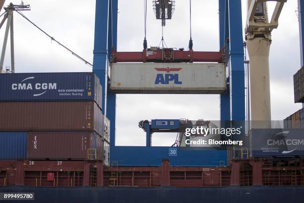 An APL Ltd. Container is loaded by crane on to the Vladimir container vessel at the Hamburger Hafen und Logistik AG Container Terminal Burchardkai in...