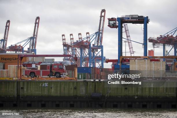 Containers and a fire truck sit dockside ready for loading at the Hamburger Hafen und Logistik AG Container Terminal Burchardkai in the Port of...