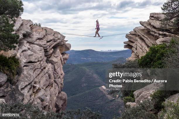 man highlining between rocky cliffs, el garbi, valencia, spain - hochseil stock-fotos und bilder