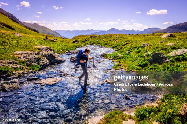 backpacker crossing high country stream. - hiking colorado stock pictures, royalty-free photos & images