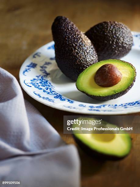 whole and halved avocado - half and half stock pictures, royalty-free photos & images