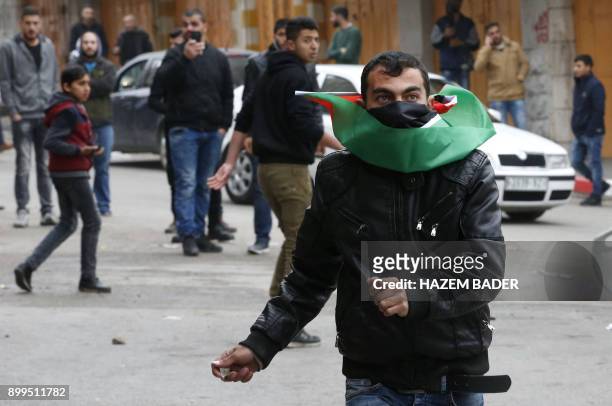 Palestinian demonstrator throws stones towards Israeli security forces during clashes in the occupied West Bank city of Hebron on December 29, 2017...