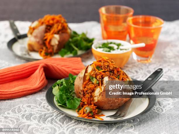 baked potatoes with chilli con carne, cheese and sour cream - chilli powder stock-fotos und bilder