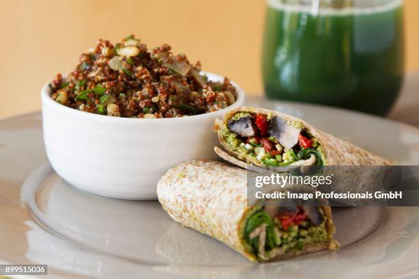 wholemeal wraps filled with portobello mushrooms, pesto, dried tomatoes and courgettes next to a bowl of quinoa with cabbage and coconut milk - zucchine stock pictures, royalty-free photos & images