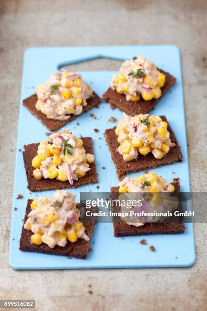 pumpernickel bread with tuna paste, sweetcorn and red onions - canap�� stock-fotos und bilder