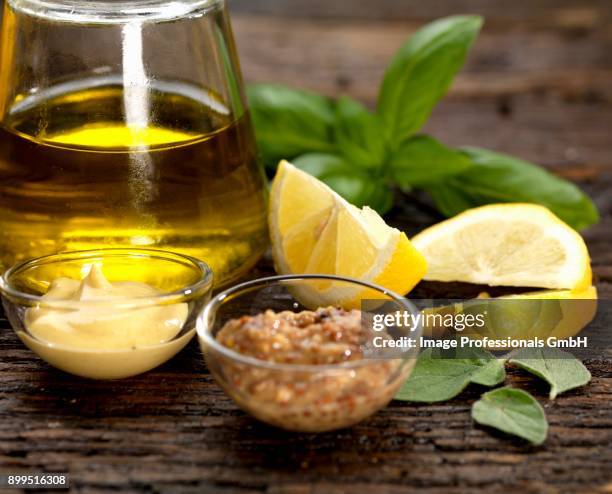 olive oil dressing ingredients with dijon mustard and wholegrain mustard with lemon basil and sage - origanum imagens e fotografias de stock